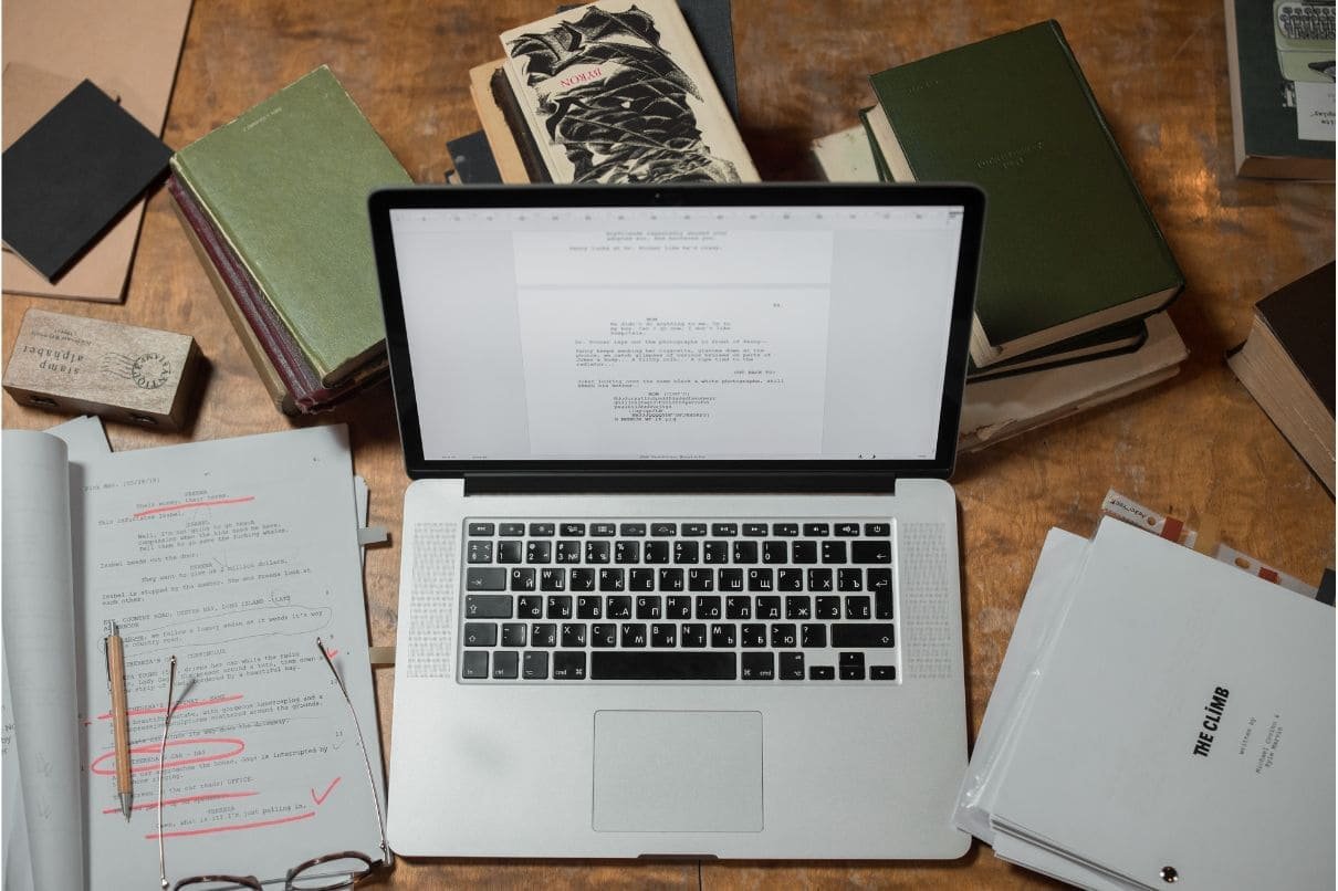 A laptop placed on a desk surrounded by books and papers, creating a productive and organized workspace